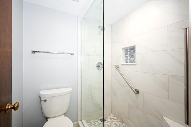 full bathroom featuring a tile shower and toilet