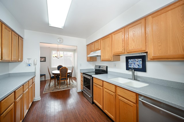 kitchen featuring dark wood finished floors, light countertops, appliances with stainless steel finishes, a sink, and under cabinet range hood