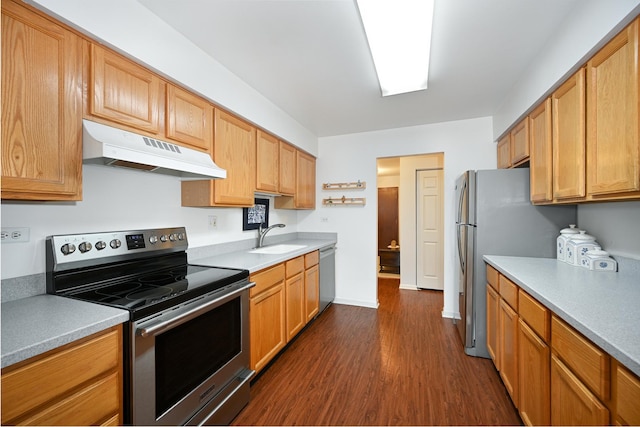 kitchen featuring under cabinet range hood, a sink, light countertops, appliances with stainless steel finishes, and dark wood-style floors