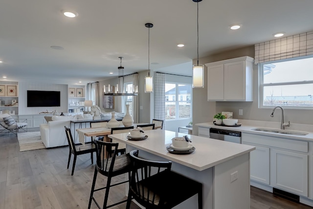 kitchen featuring dishwasher, a center island, and white cabinets