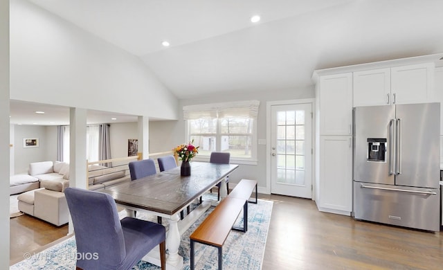 dining room with lofted ceiling, light wood-type flooring, and recessed lighting