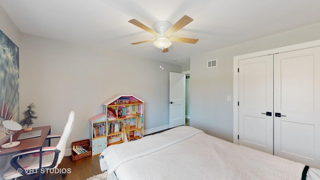 bedroom featuring a ceiling fan, visible vents, a closet, and wood finished floors