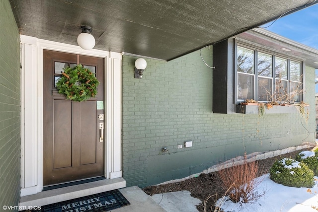 doorway to property with brick siding