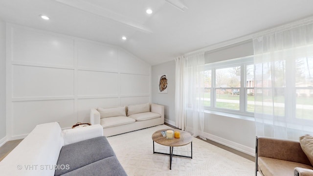 living room with vaulted ceiling, recessed lighting, light wood-style flooring, and a decorative wall