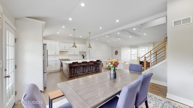 dining space featuring recessed lighting, visible vents, lofted ceiling with beams, light wood-style floors, and baseboards