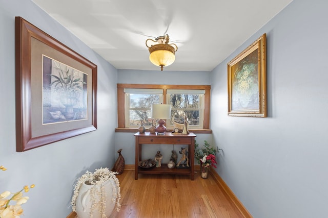 hallway featuring baseboards and light wood finished floors