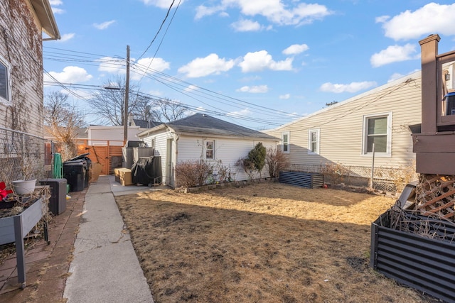 view of side of property with fence and a lawn