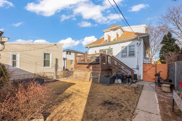 back of house with a deck, stairway, fence, and a gate