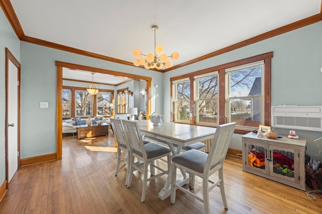 dining room with ornamental molding, a notable chandelier, baseboards, and hardwood / wood-style flooring