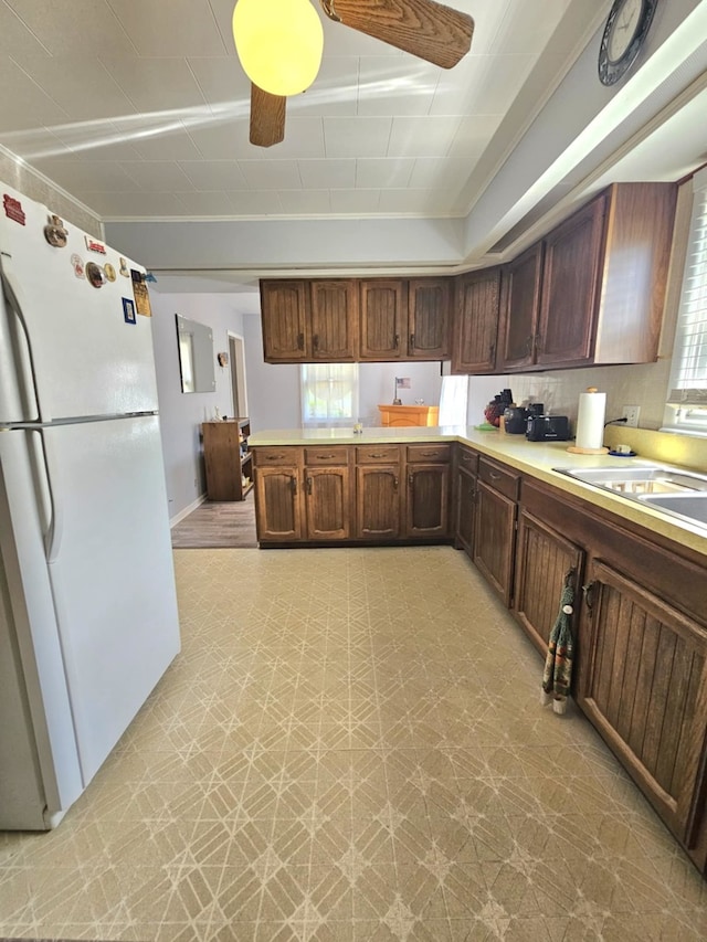 319 S Reed St, Joliet, IL 60436 - kitchen with freestanding refrigerator, light countertops, light flooring, a ceiling fan, and a peninsula