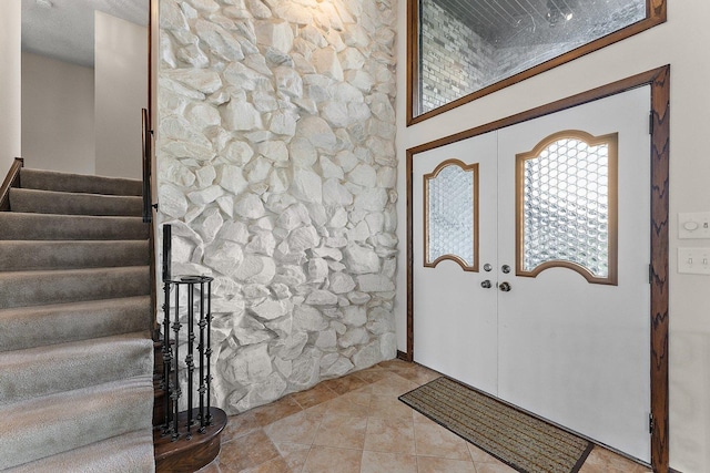 entryway with french doors and light tile patterned floors