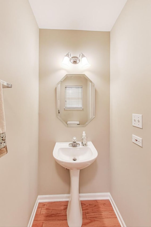 bathroom with wood finished floors and baseboards