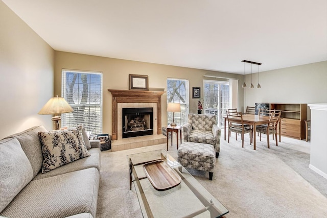 living area with light carpet and a tile fireplace