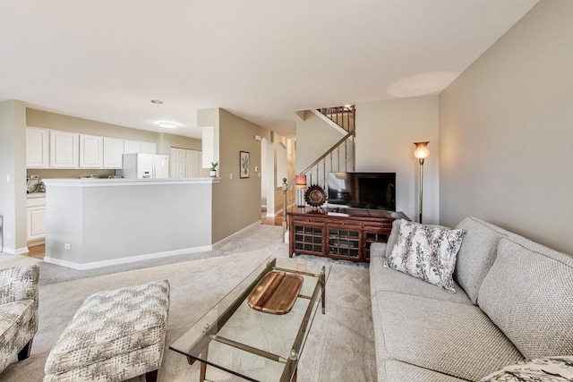 living area featuring light carpet, stairs, and baseboards