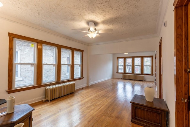 unfurnished living room with radiator, light hardwood / wood-style flooring, and ornamental molding