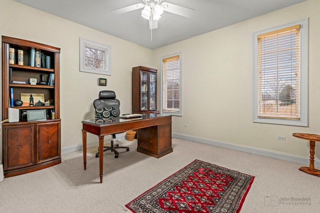 carpeted office with a ceiling fan and baseboards