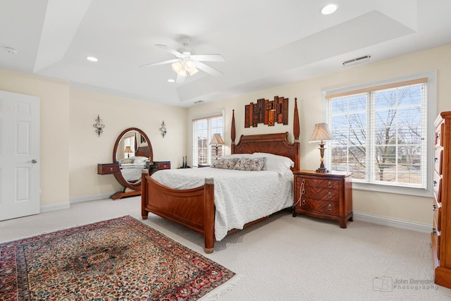 bedroom with a tray ceiling, recessed lighting, visible vents, and baseboards