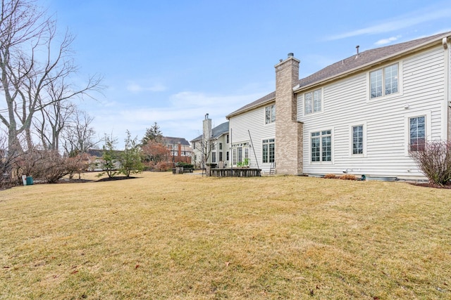 back of house with a yard and a chimney