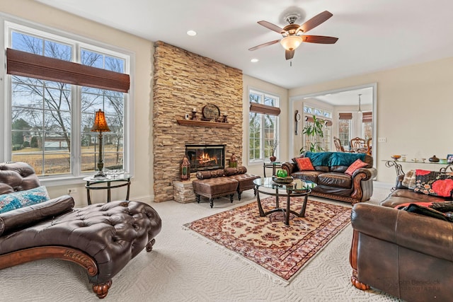 living room with carpet floors, a fireplace, baseboards, and a ceiling fan