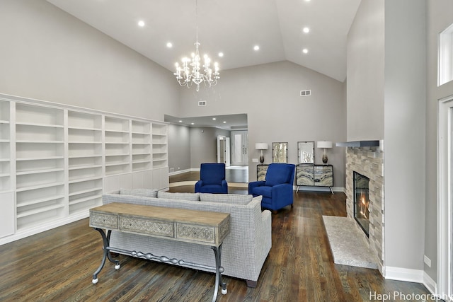 living room with a notable chandelier, a fireplace, high vaulted ceiling, and dark hardwood / wood-style floors