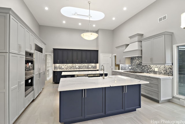 kitchen featuring decorative light fixtures, gray cabinets, and a spacious island