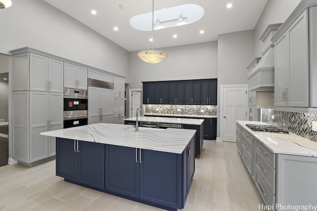 kitchen with appliances with stainless steel finishes, a large island, gray cabinets, and sink