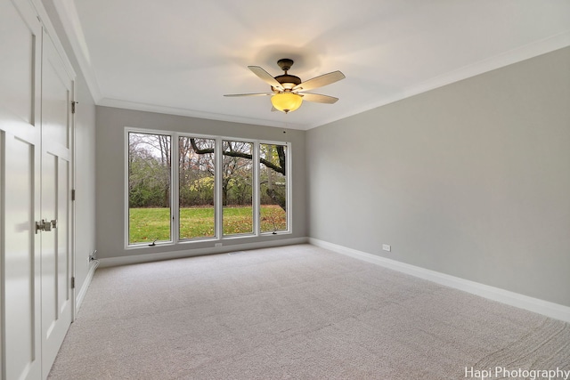 unfurnished room featuring ornamental molding, light carpet, and ceiling fan