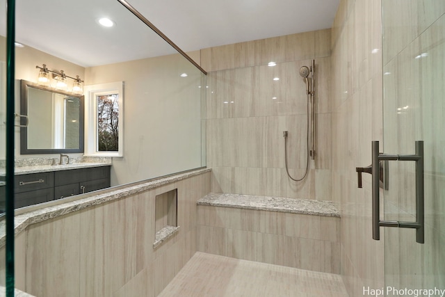 bathroom with vanity and a shower with door