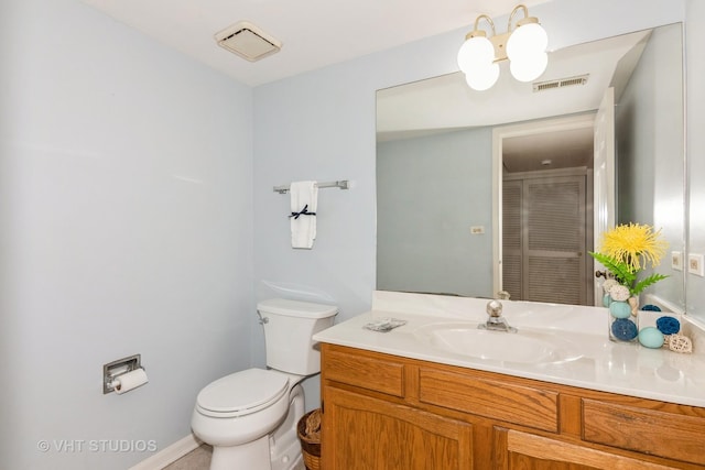 bathroom featuring toilet, vanity, and visible vents