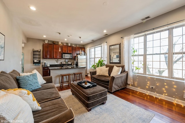 living area featuring recessed lighting, wood finished floors, visible vents, and baseboards