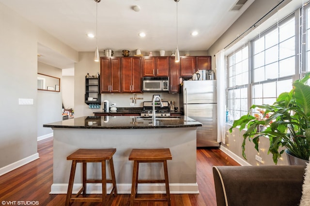 kitchen with a sink, visible vents, appliances with stainless steel finishes, and dark wood-style flooring