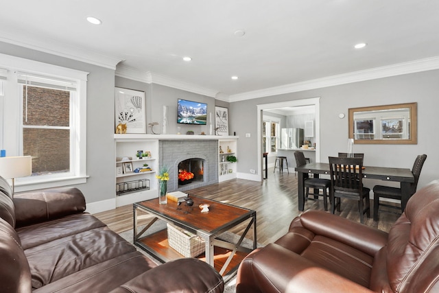 living room with ornamental molding, a fireplace, wood finished floors, and recessed lighting