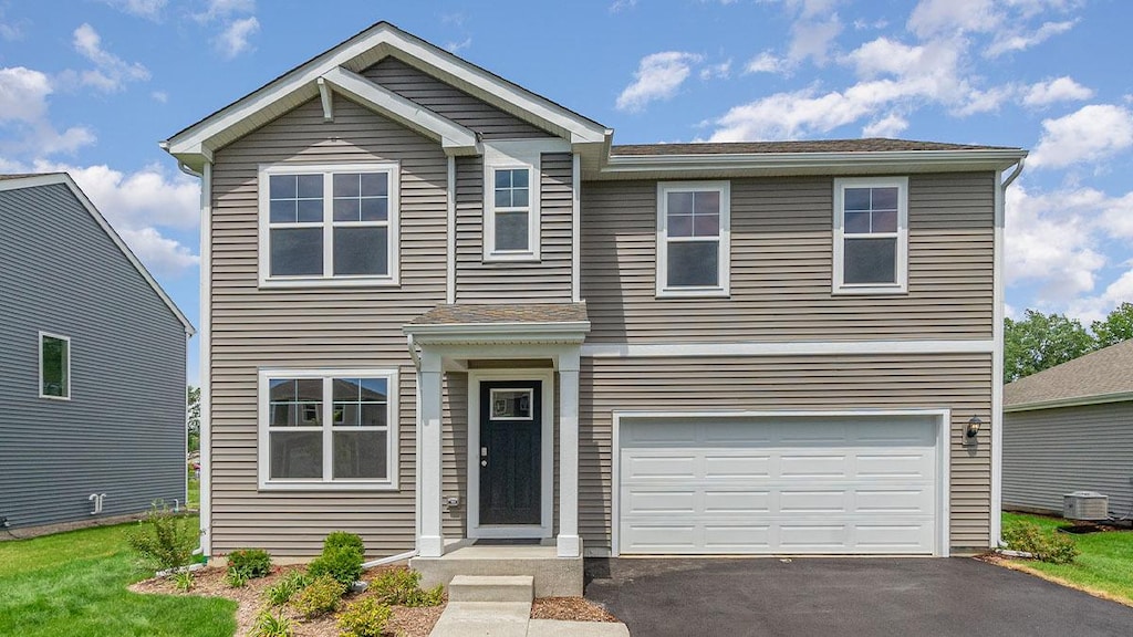 view of front of home with a garage and central air condition unit