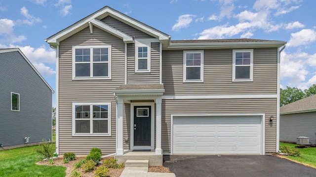 view of front of home with a garage and central air condition unit