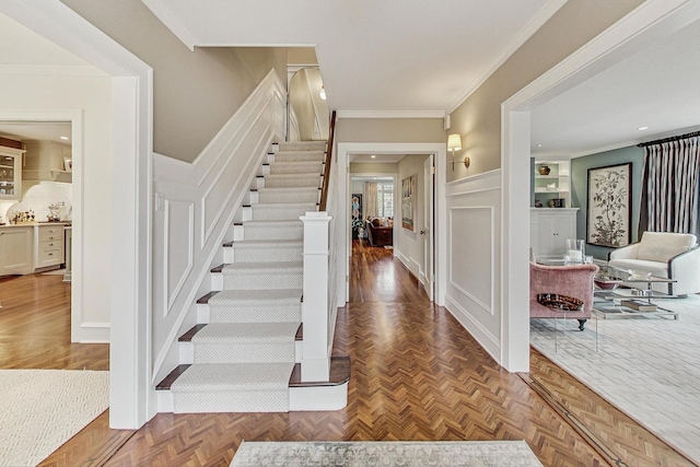 entryway with parquet floors and ornamental molding