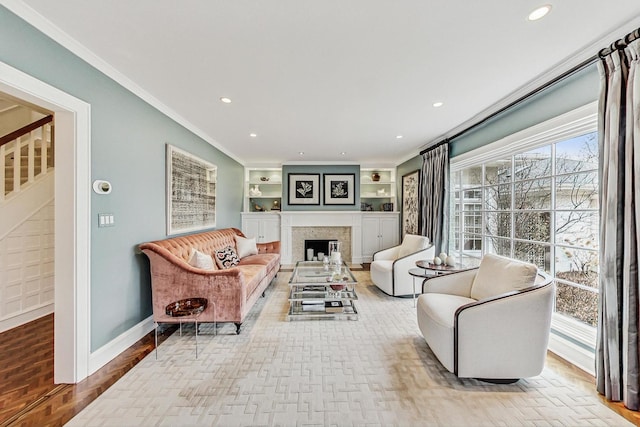 living room with ornamental molding and built in shelves