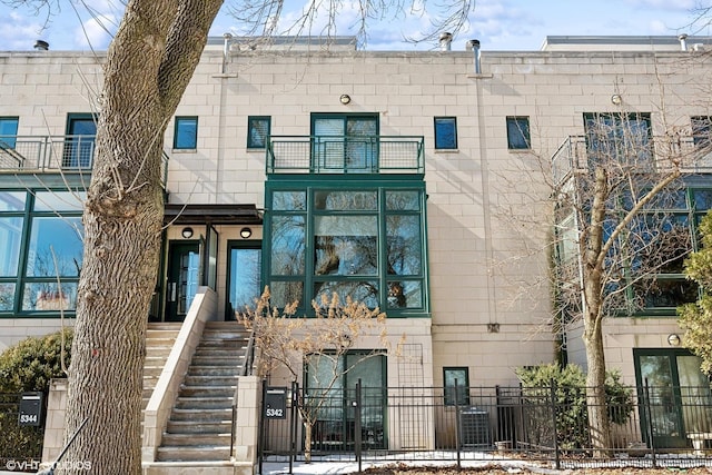 view of property featuring a fenced front yard and stairs