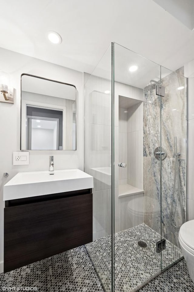 bathroom featuring toilet, tile patterned flooring, vanity, a shower stall, and recessed lighting