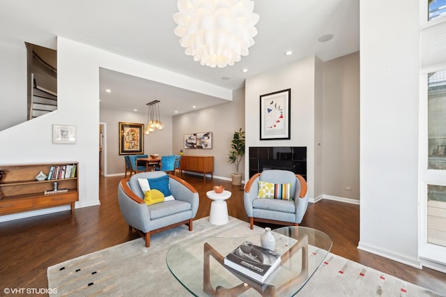 living area with baseboards, a chandelier, wood finished floors, and recessed lighting