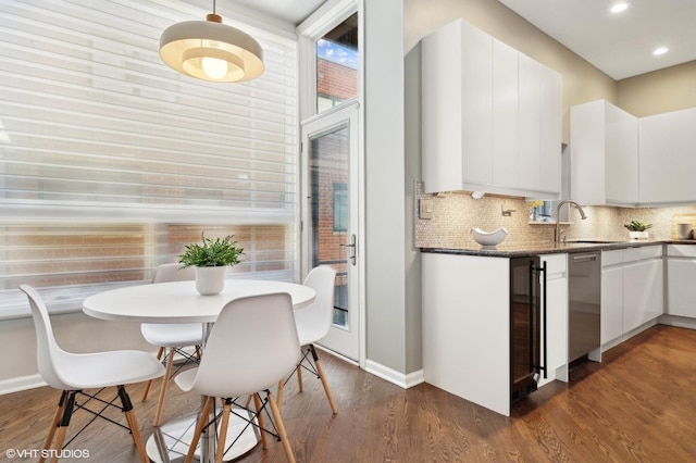 kitchen featuring decorative backsplash, dishwasher, dark wood-style floors, white cabinetry, and a sink