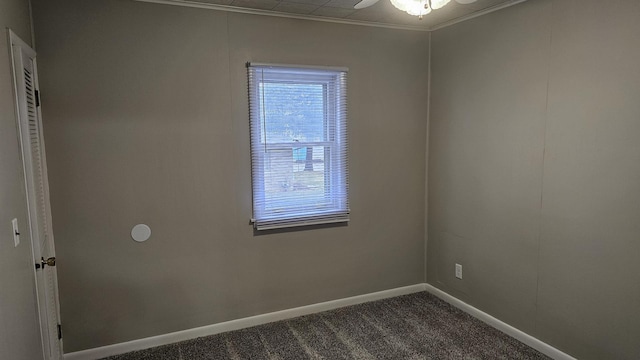 carpeted empty room featuring ceiling fan, crown molding, and a healthy amount of sunlight