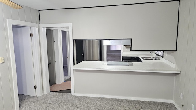 kitchen with light carpet, sink, wooden walls, and kitchen peninsula