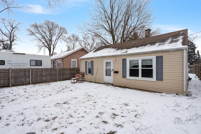 view of snow covered back of property