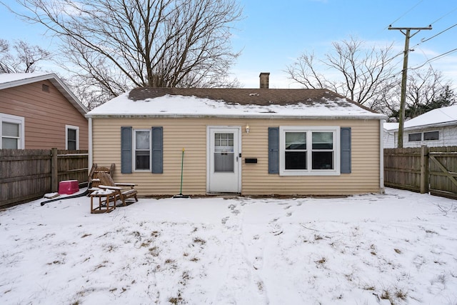 view of snow covered back of property