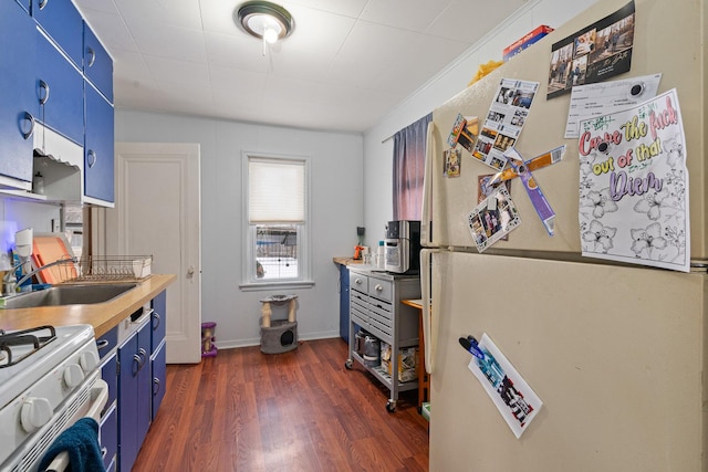 kitchen with sink, white appliances, dark hardwood / wood-style floors, and blue cabinets