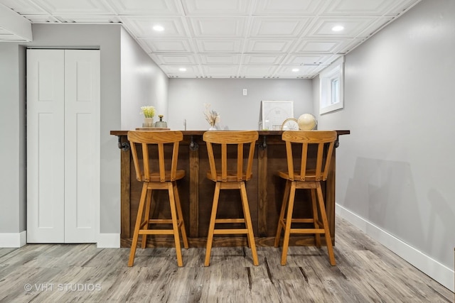 bar with light hardwood / wood-style floors