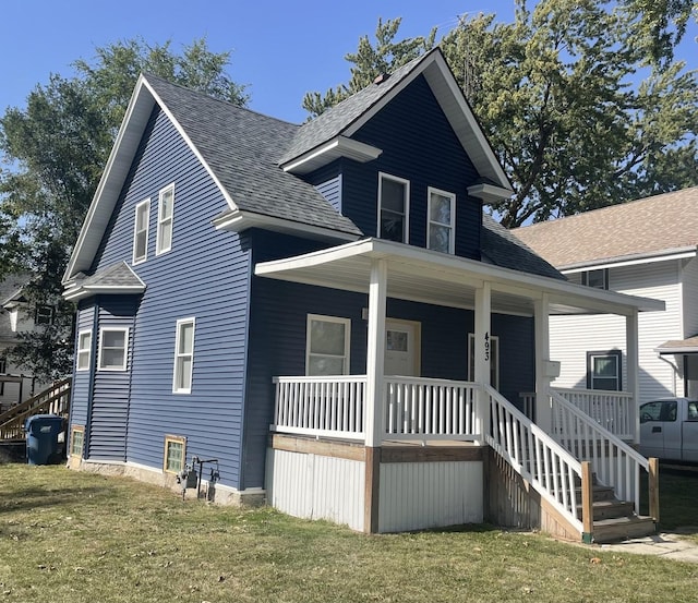 view of front of property featuring covered porch and a front yard