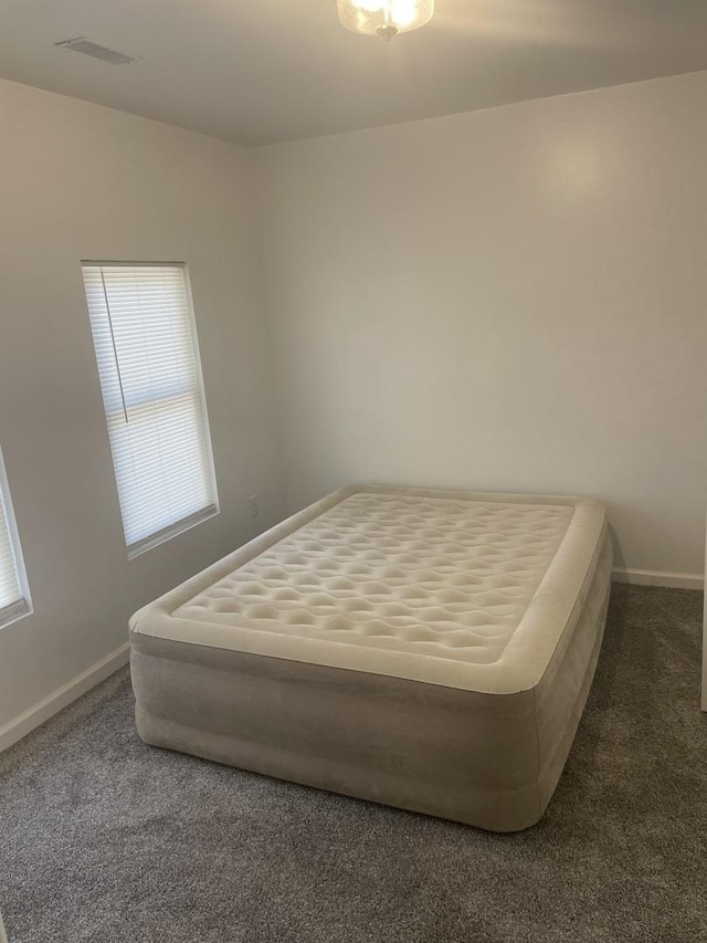 bedroom featuring dark colored carpet