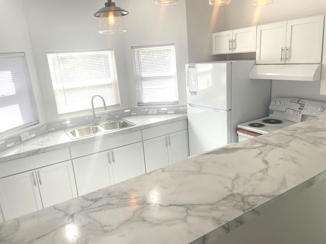 kitchen with white appliances, sink, hanging light fixtures, and white cabinets