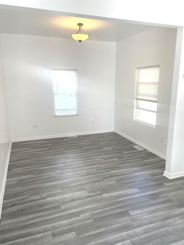 unfurnished room with dark wood-type flooring